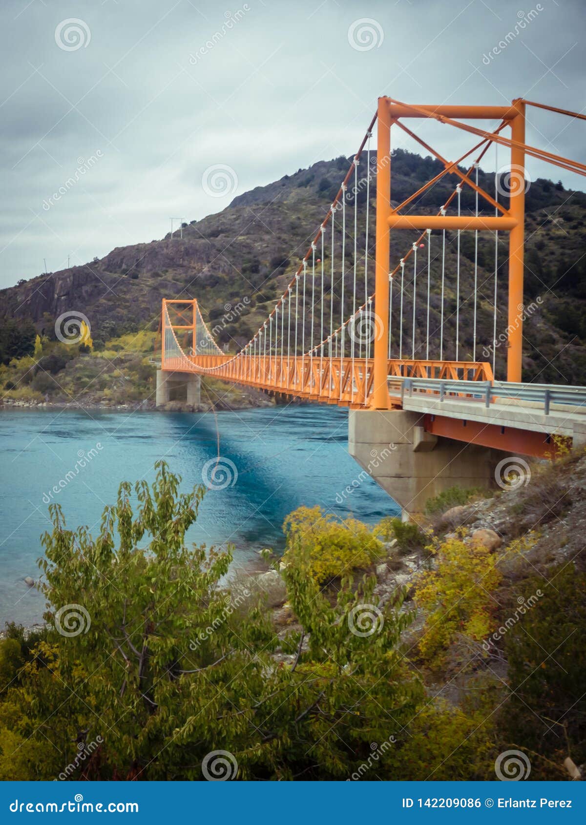 red suspension bridge over the water runoff of general carrera lake, near lake bertrand, puerto tranquilo, chile chico, aysen,