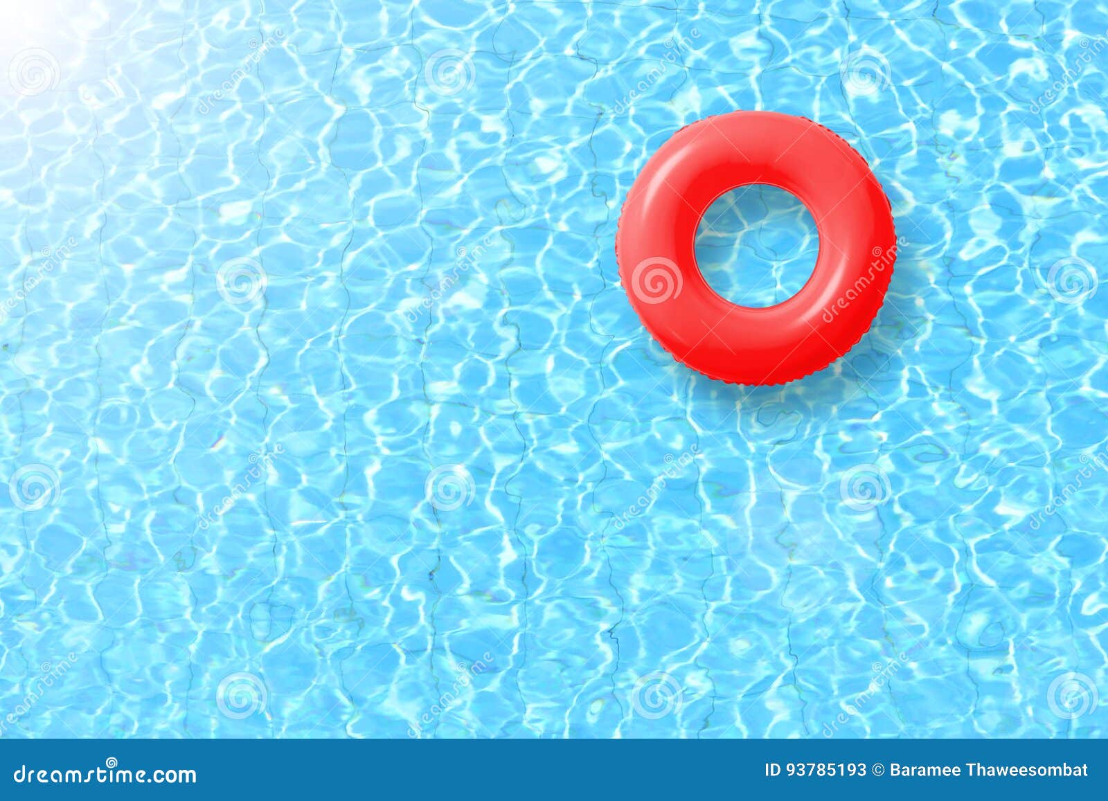 red swimming pool ring float in blue water and sun bright.