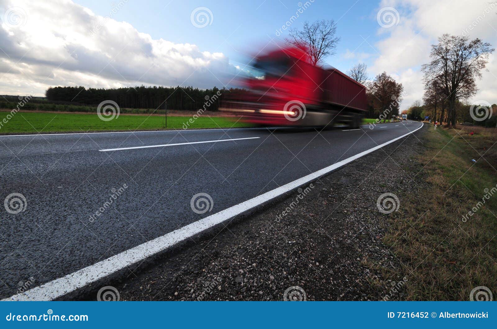 red truck in a motion on tarmac road