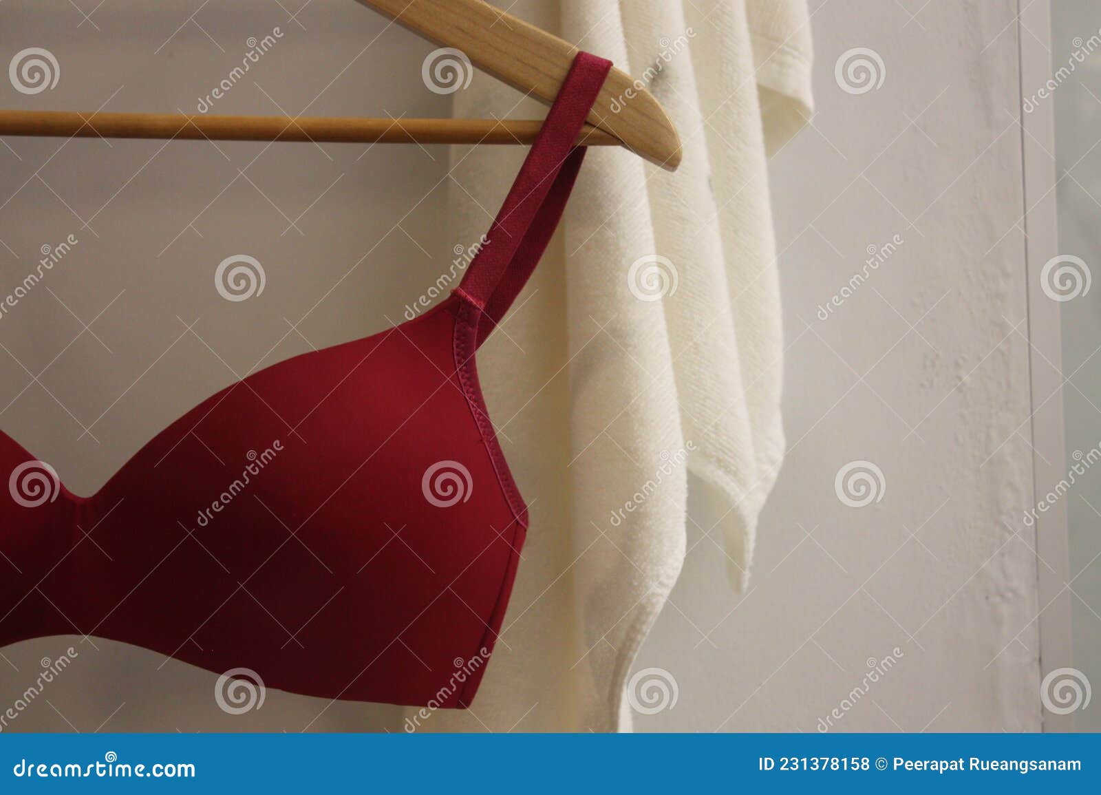 Red Underwire T-shirt Bra with White Towel Background. Stock Photo