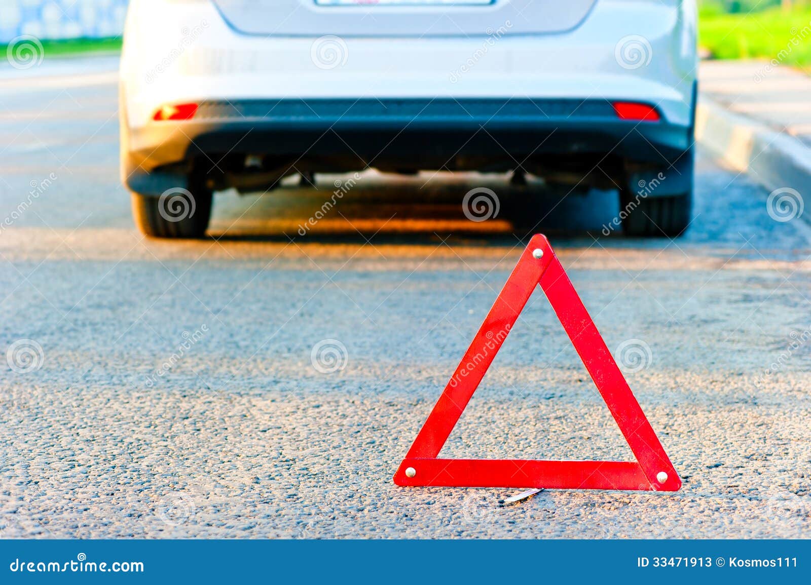 Red warning triangle and a car pull over to the side of the road