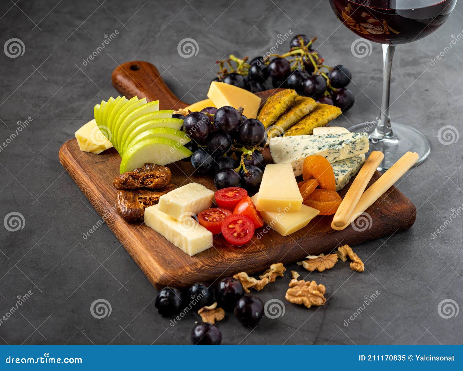 Red Wine and Assorted Cheese Plate with Fruit on Wooden Plate Stock