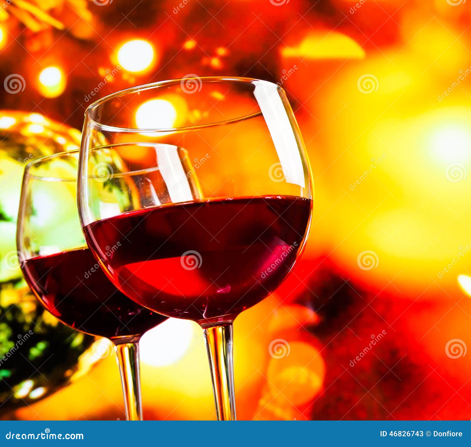 red wine glasses against colorful unfocused lights background