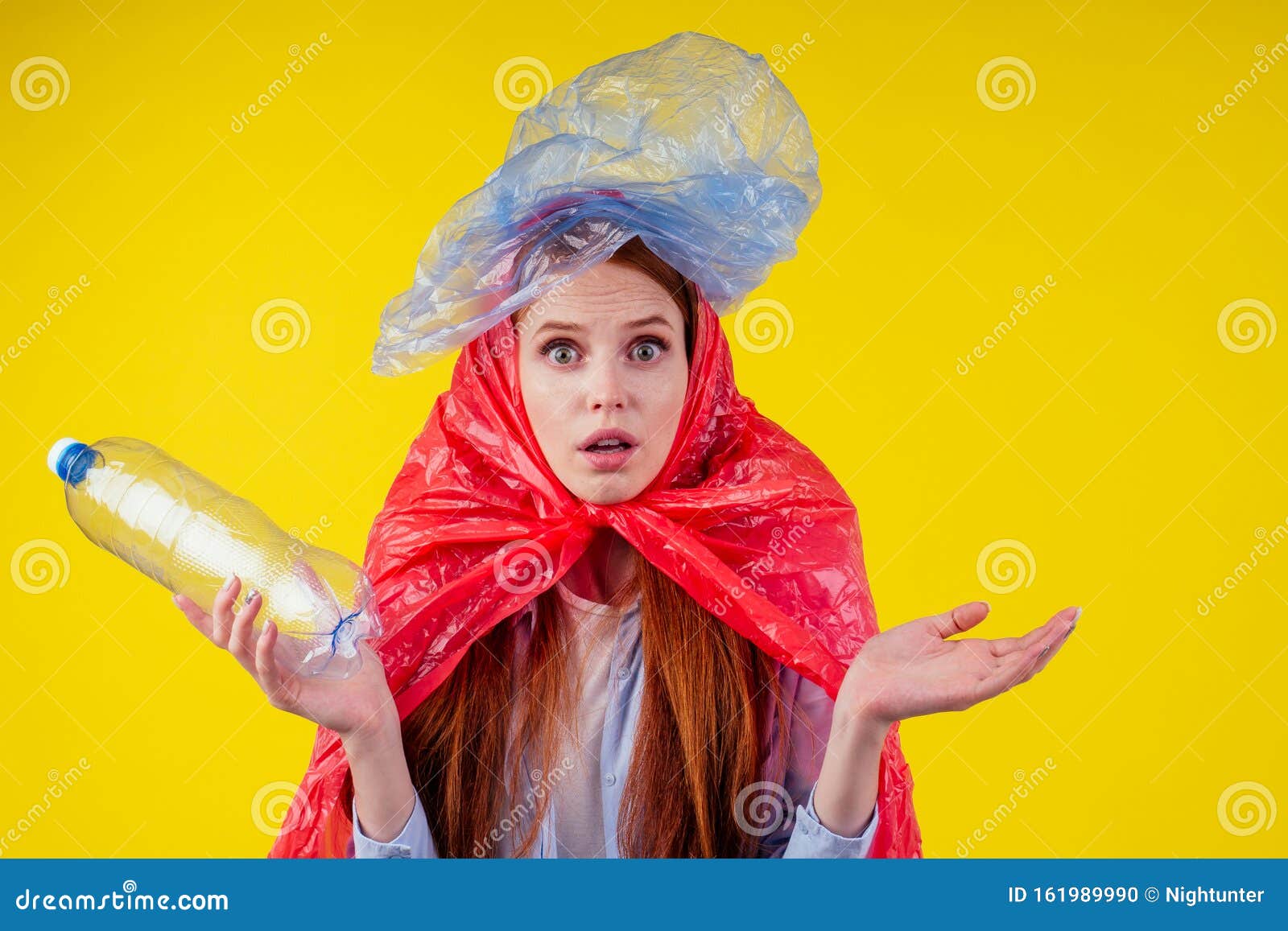 redhead ginger girl with consternation on her face pointing finger copyspase with bad full of non-eco plastic trash in