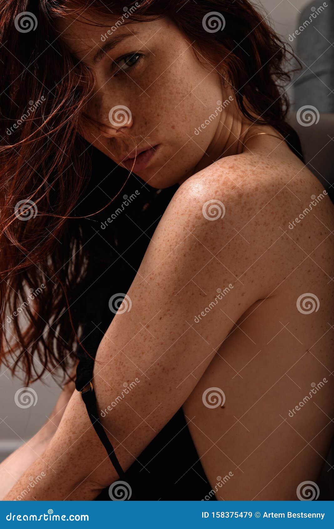 Redhead Girl With Freckles In A Black Bodysuit Looks Over He