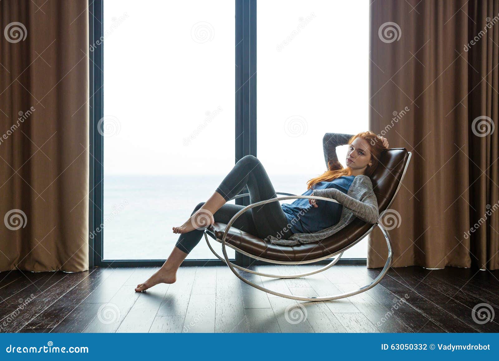 redhead woman sitting on rocking chair