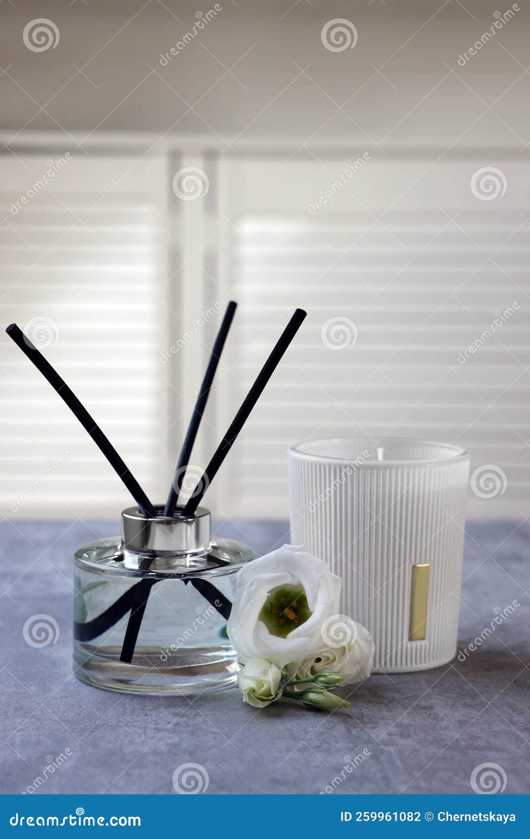 Reed Diffuser, Scented Candle and Eustoma Flowers on Gray Marble Table Editorial Photography