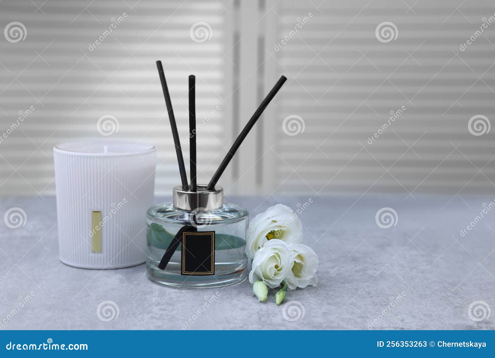 Reed Diffuser, Scented Candle and Eustoma Flowers on Gray Marble Table, Space for Text Stock