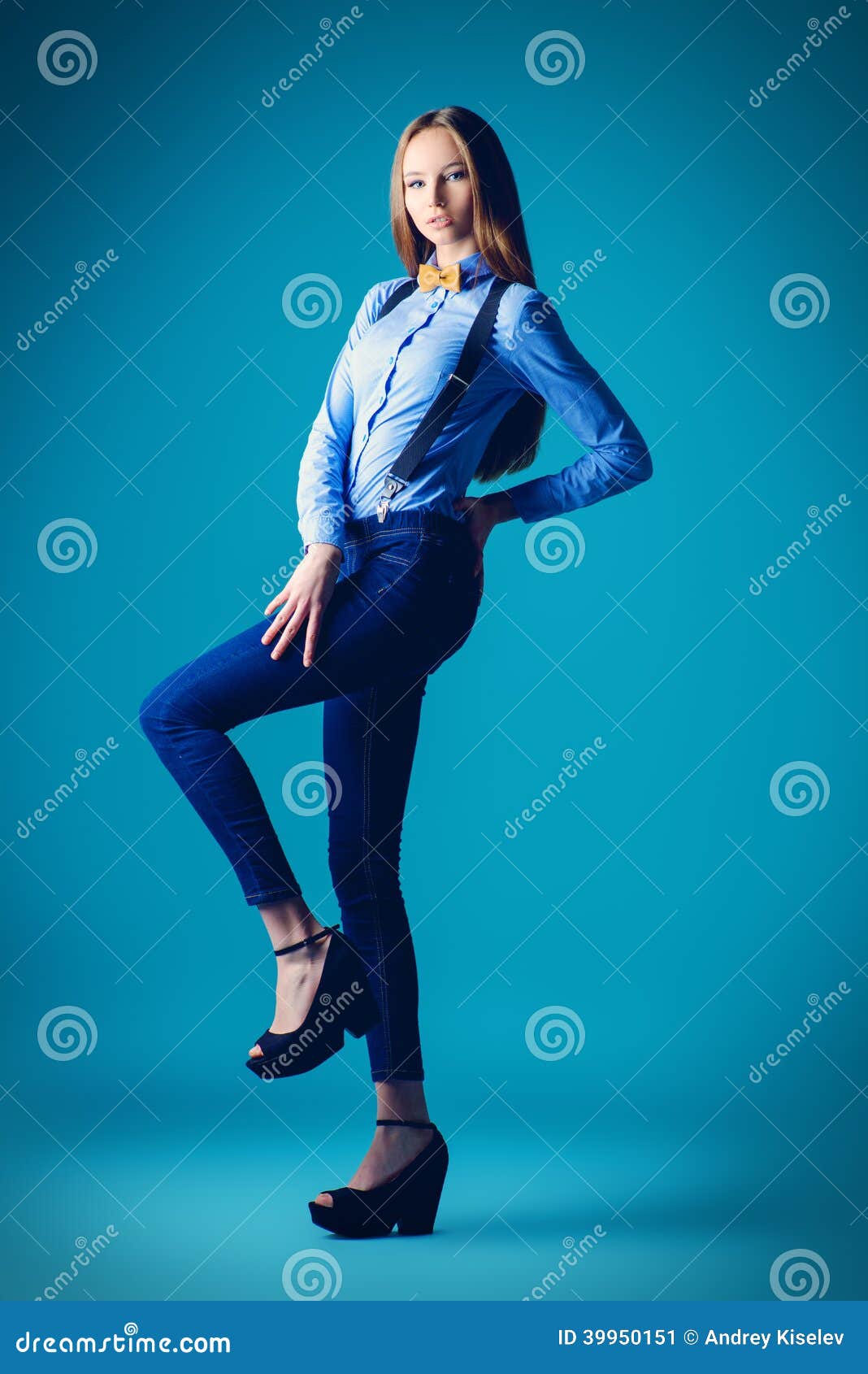Kid Fashion, Style. Girl Model Pose In Jeans Overall Full Length. Beauty,  Look Concept. Child With Long Healthy Brunette Hair On Blue Background.  Youth, Skincare, Health. Stock Photo, Picture and Royalty Free