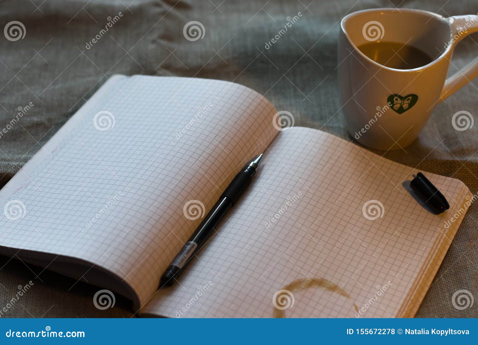 refiner from a cup of coffee on the notebook on the table ander the lump light