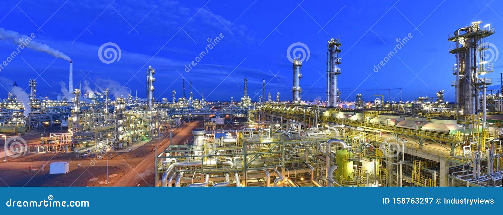refinery - chemical factory at night with buildings, pipelines and lighting - industrial plant