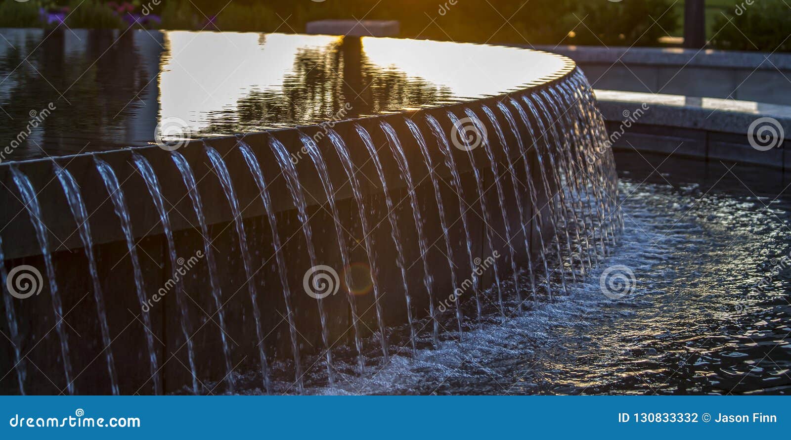 reflections on the water of a fountain at sunset