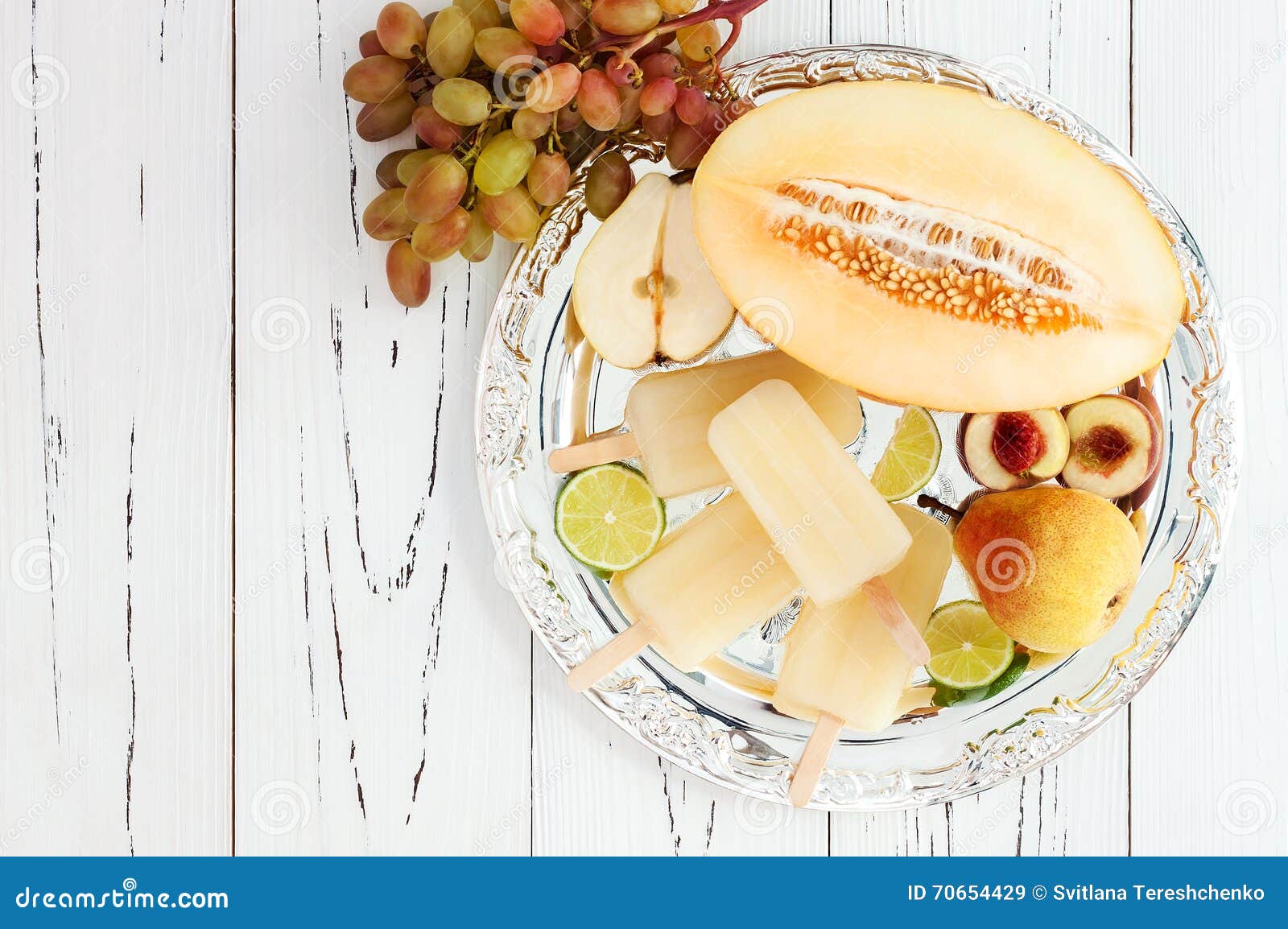 refreshing ice pops over silver tray. pear, peach, grape, lime, honeydew white sangria paletas - popsicles. top view