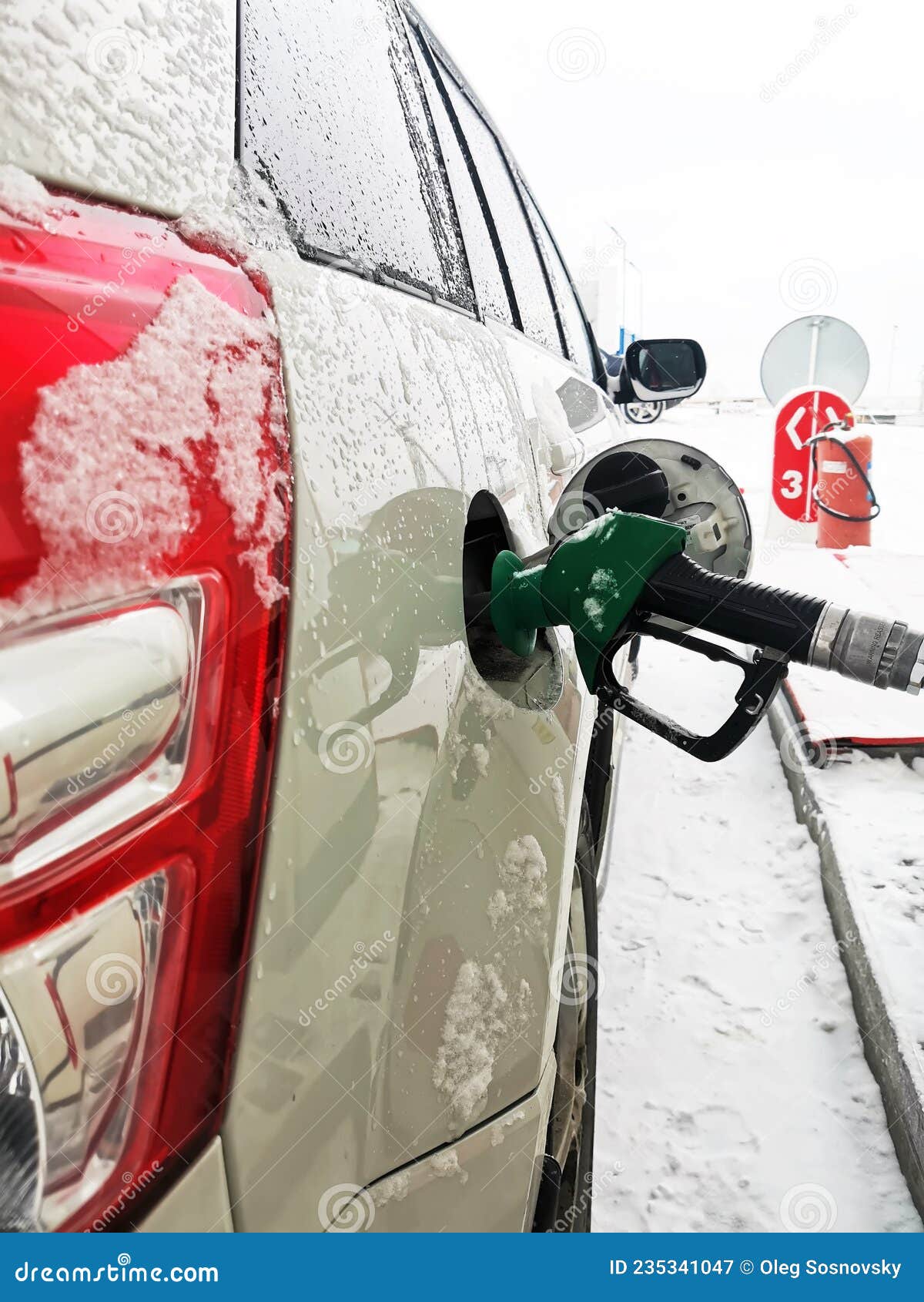 The Refueling Pistol is Inserted into the Car`s Gas Tank in Winter