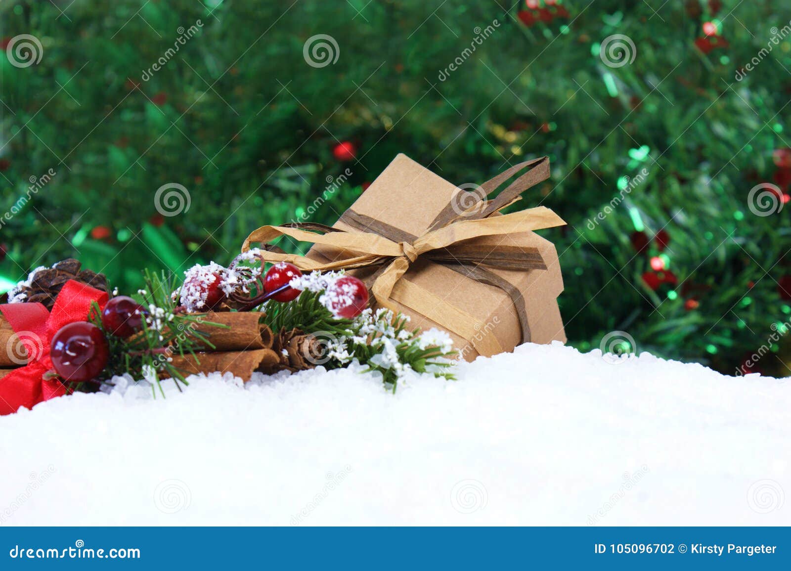 Regalo e decorazioni di Natale accoccolati in neve. Il regalo e le decorazioni di Natale si sono accoccolati in neve con il fondo delle luci del bokeh