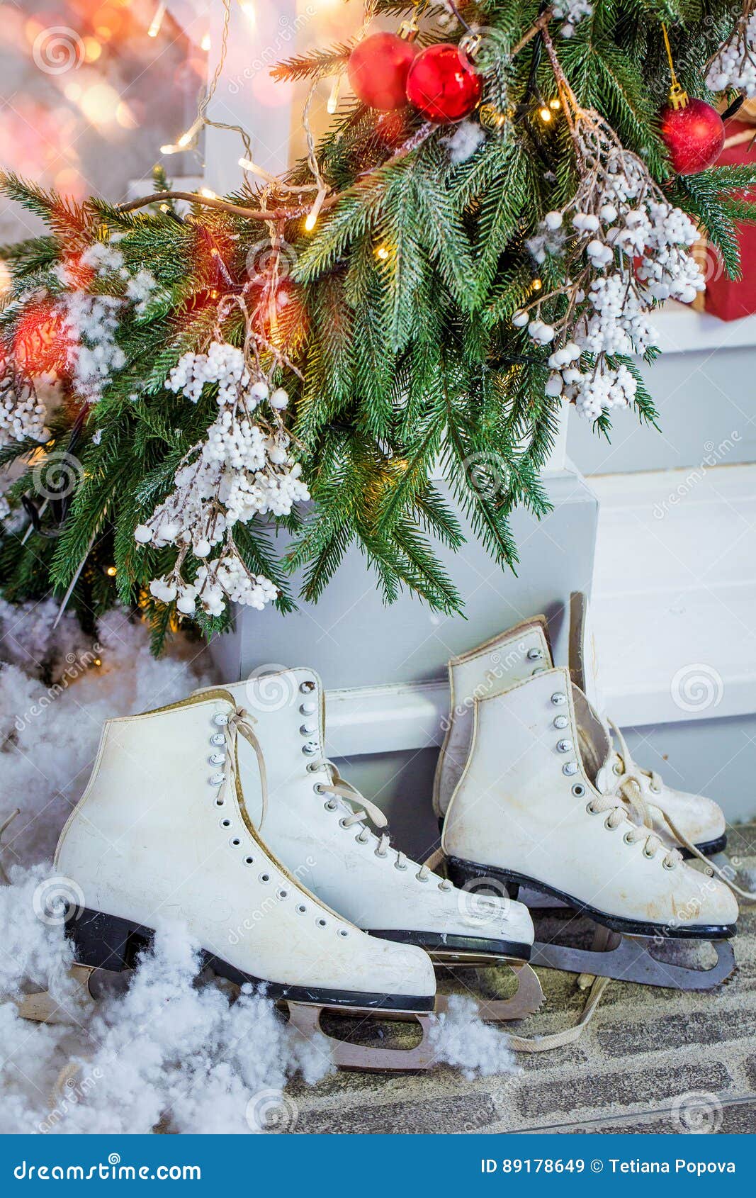 Los regalos de la Navidad, patines, se llevan debajo del árbol