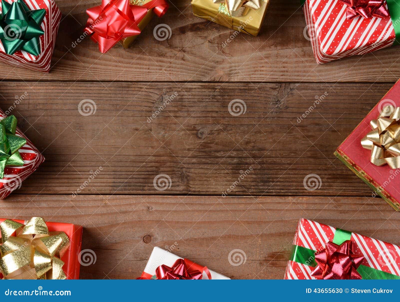 Regalos de Navidad de madera rústicos del piso. Una opinión de alto ángulo de un grupo de regalos de Navidad en un piso de madera rústico Los presentes se dispersan alrededor de los bordes del bastidor que sale de un centro vacío para su objeto o copian