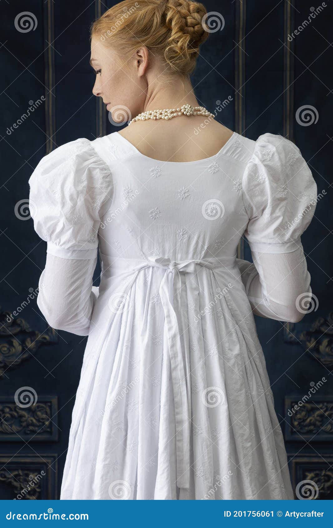a regency woman wearing a white cotton muslin dress and standing in a room