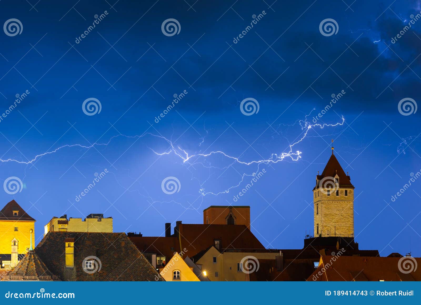 regensburg, bavaria, germany, historic town hall tower and skyline of old town during summer thunderstorm with flashes and