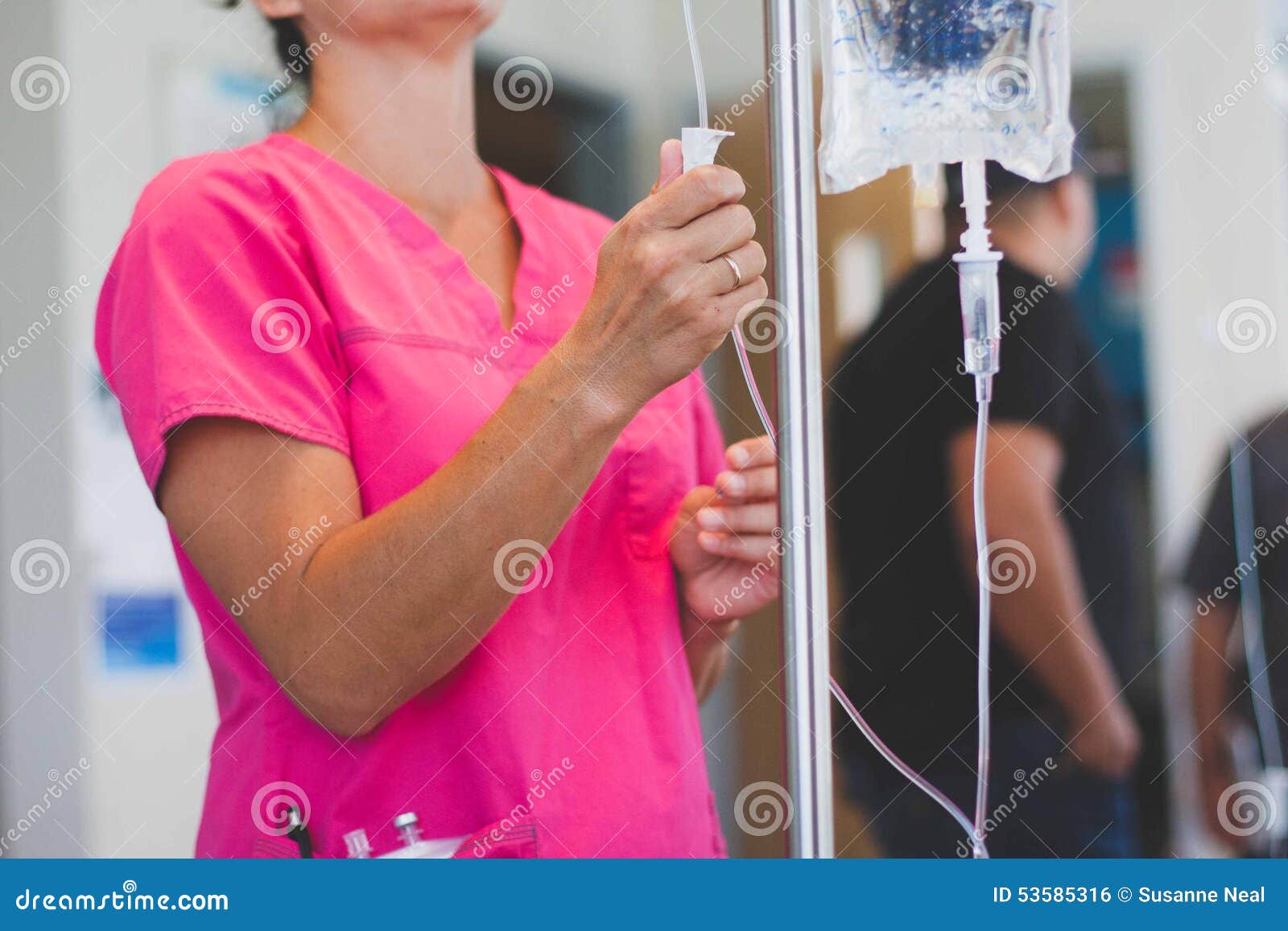 registered nurse wearing hot pink scrubs hangs iv
