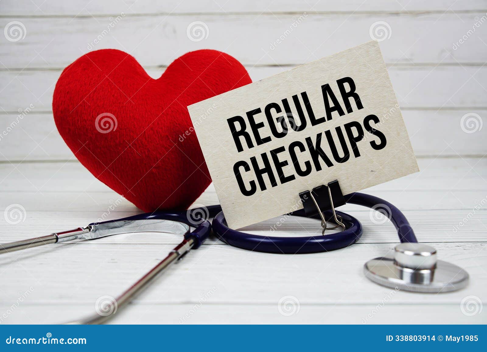 regular checkups text message on paper card with stethoscope on wooden background