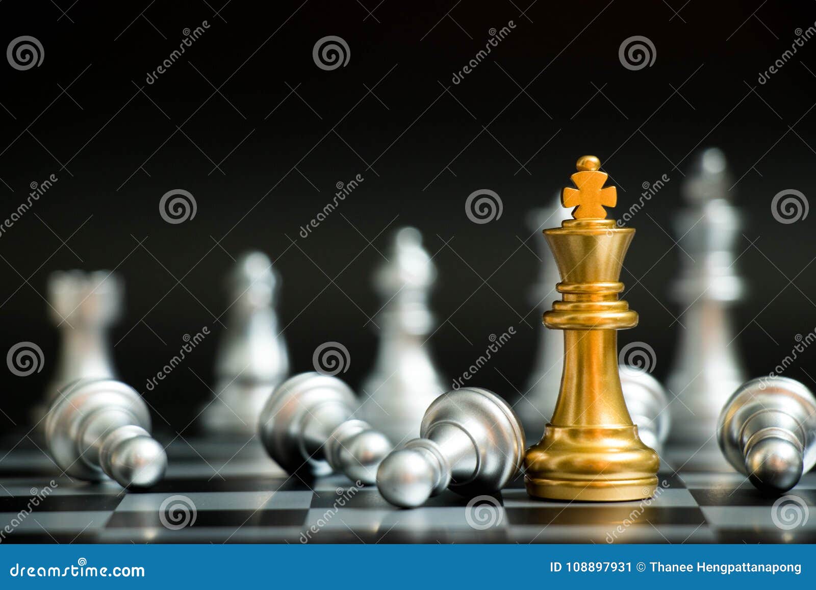 Mão segurando o rei do xadrez de ouro sobre o rei do xadrez de prata
