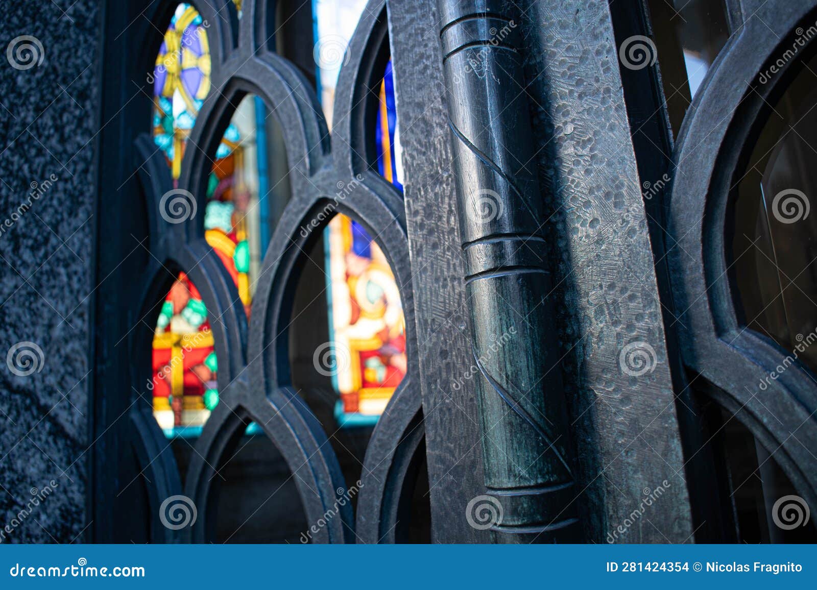 colorful stained glass window seen through a fence in recoleta cemetery in argentina