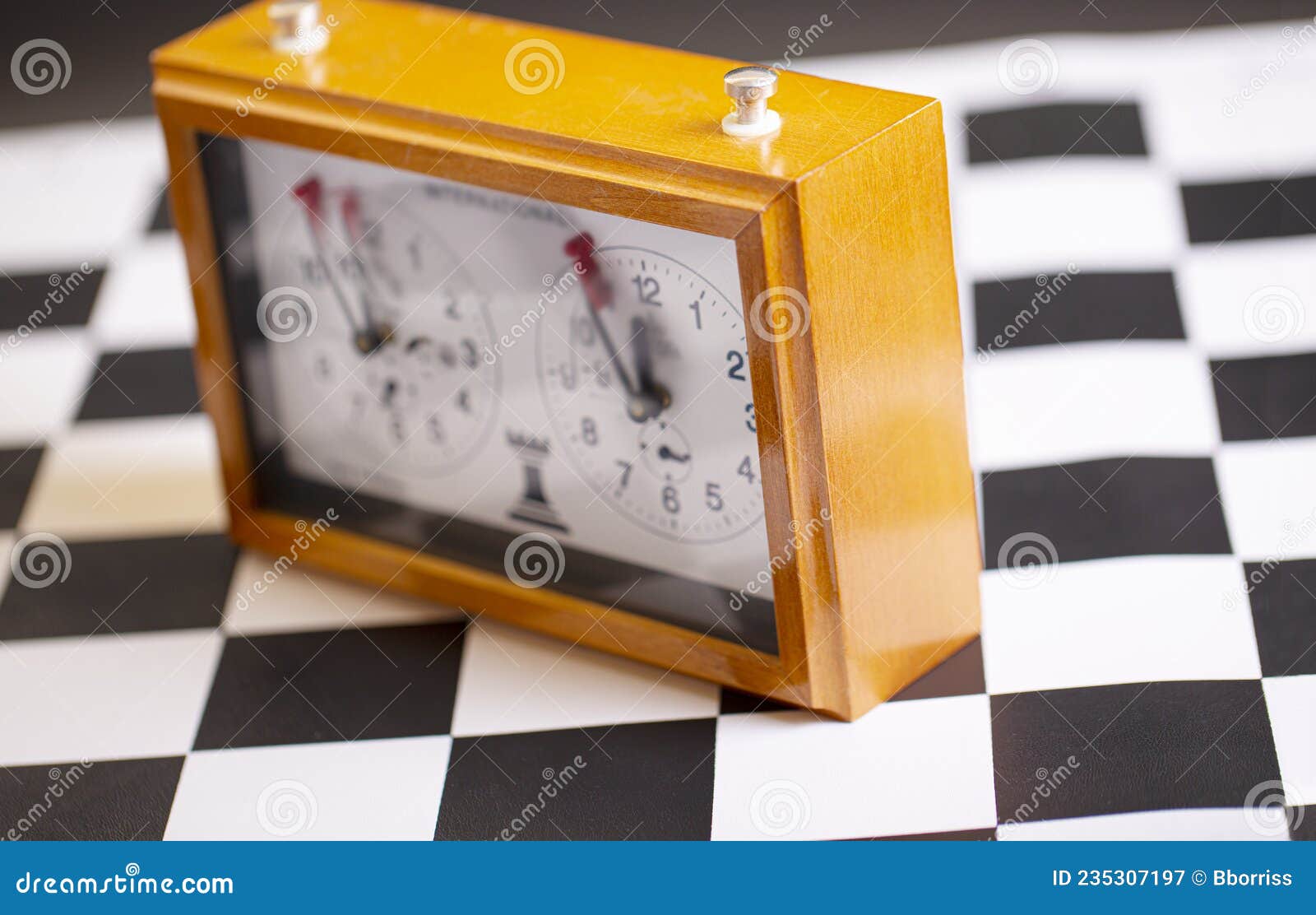 Relógio de xadrez mecânico clássico no foco seletivo do tabuleiro de xadrez  de madeira