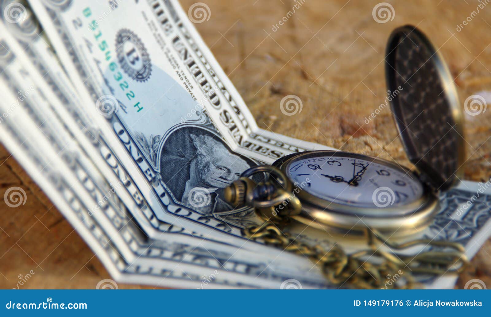 Rel?gio de bolso com d?lares no tronco de madeira. Pocket watch with dollars on wooden trunk. Time of money. American dollars and copper timepiece with chain on wooden background