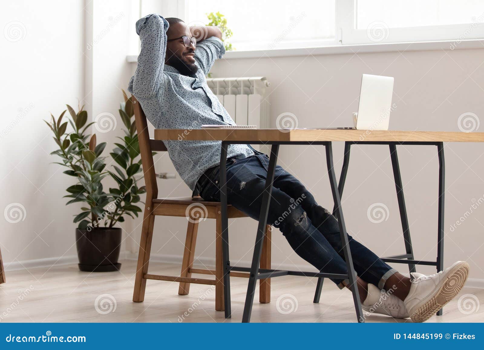 relaxed african american businessman chilling in office room finished work