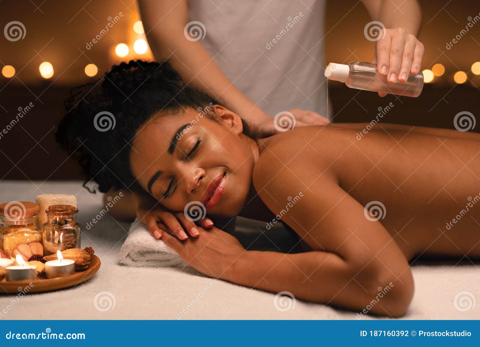 Relaxed African Woman Enjoying Aromatherapy And Massage At Spa Stock