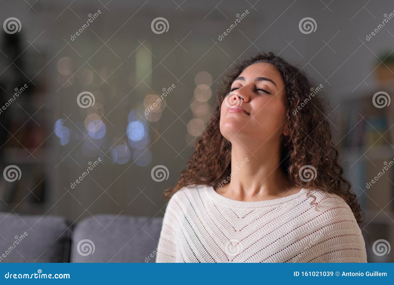 relaxed woman breathing fresh air in the night at home