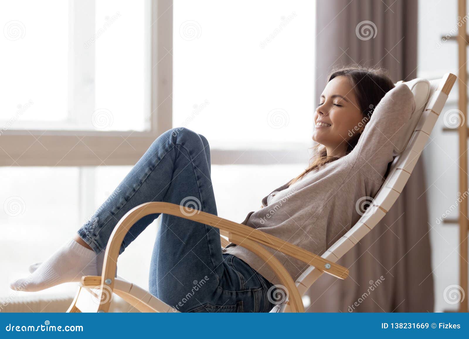 relaxed calm young woman lounging sitting in comfortable rocking chair