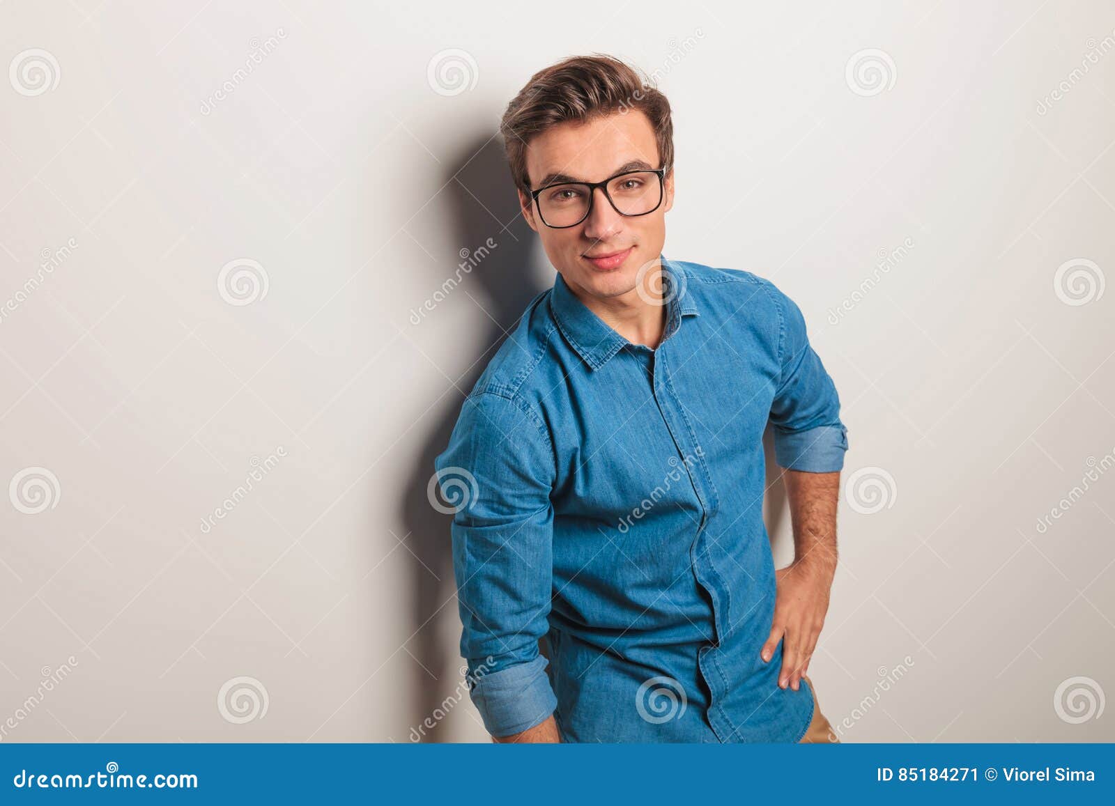 Relaxed Casual Man with Hand on Waist Leaning on Wall Stock Image ...