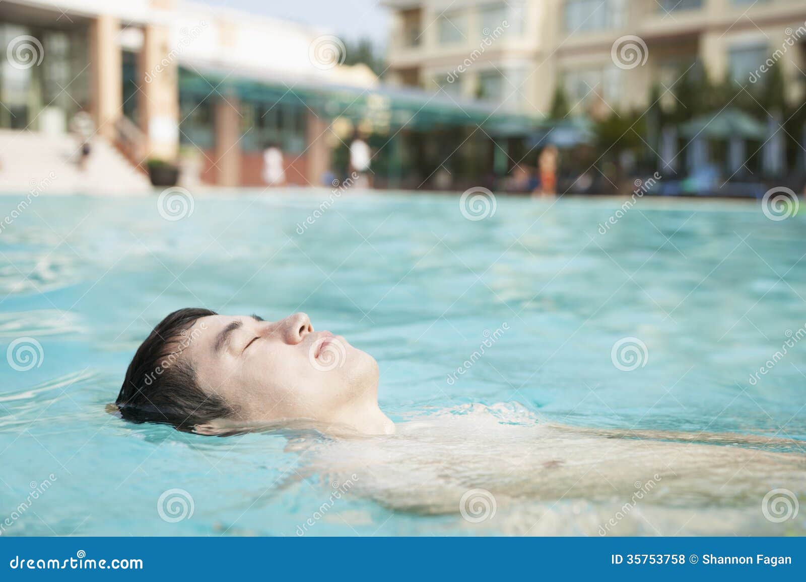 Relaxed Man Floating in the Pool with Eyes Closed Stock Photo Image