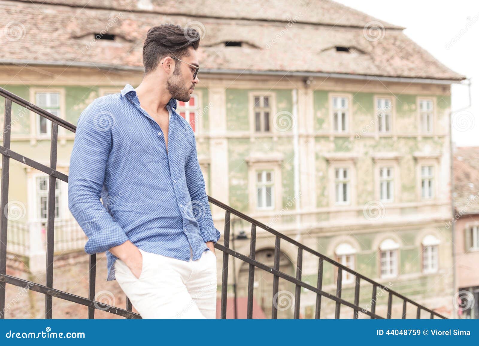 Relaxed Man with Hands in Pockets Looking Down the Stairs Stock Image