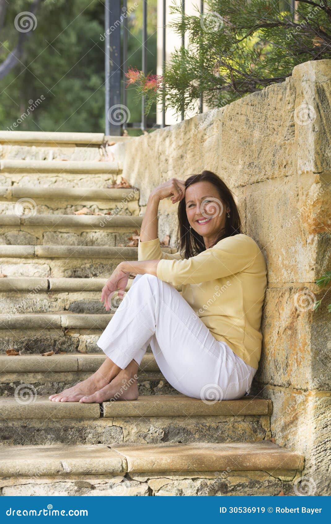 relaxed smiling mature woman outdoor portrait confident beautiful sitting happy limestone steps park bare feet 30536919 - Modelle nude Le gallerie più grandi del mondo