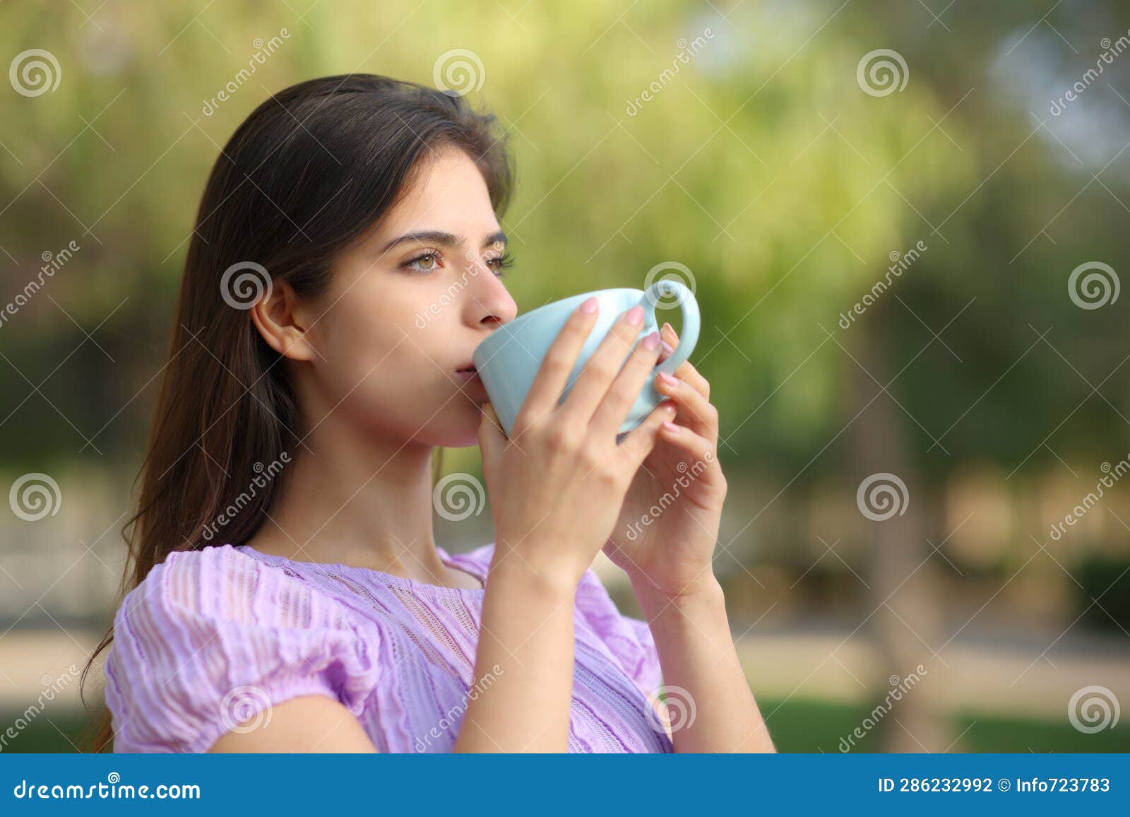 relaxed woman drinking coffee in a park