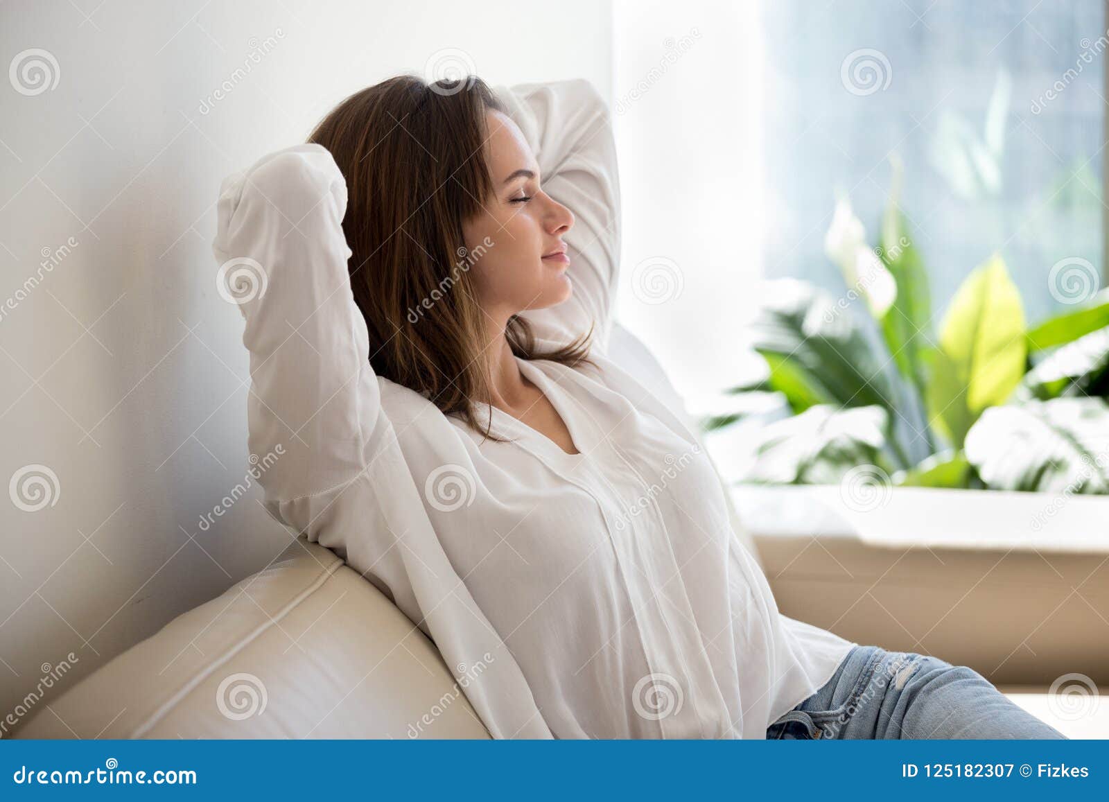 relaxed woman resting breathing fresh air at home on sofa