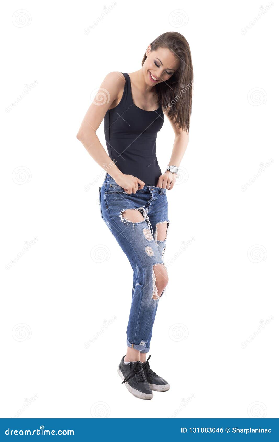 Relaxed Young Beauty Woman in Ripped Trendy Jeans Looking Down and ...