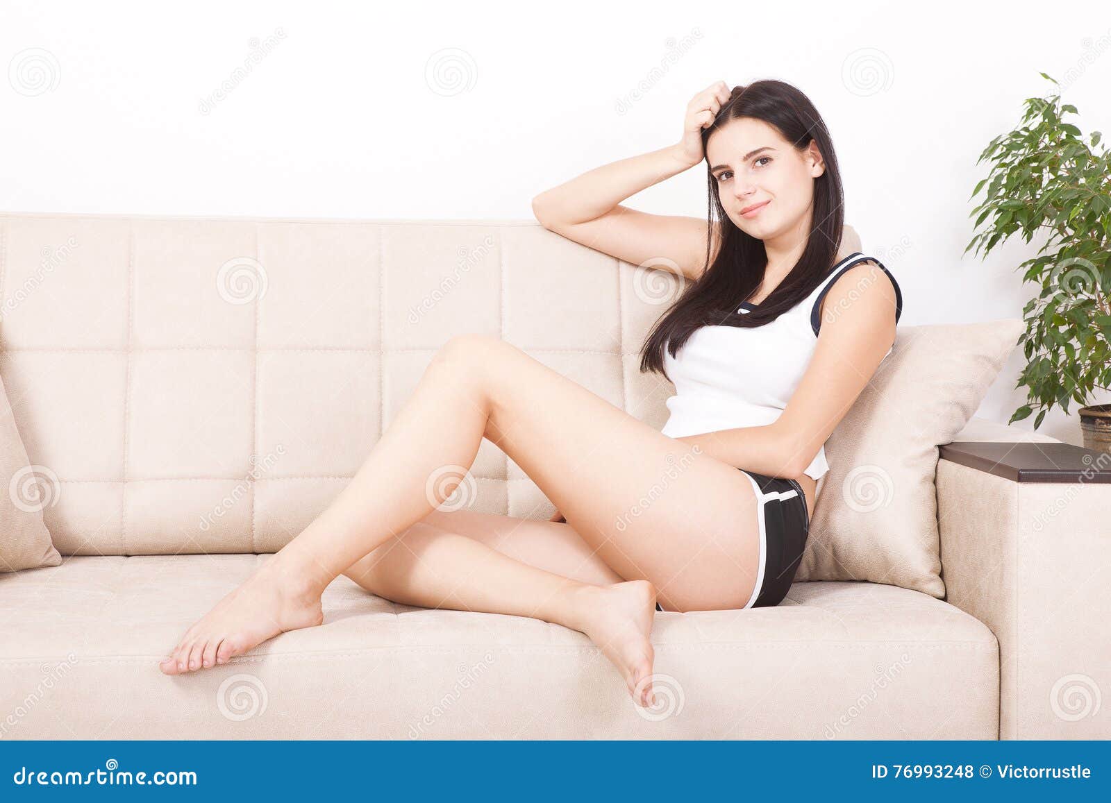 Relaxing Woman Sitting Comfortable in Sofa Lounge Smiling Happy Looking at Camera photo