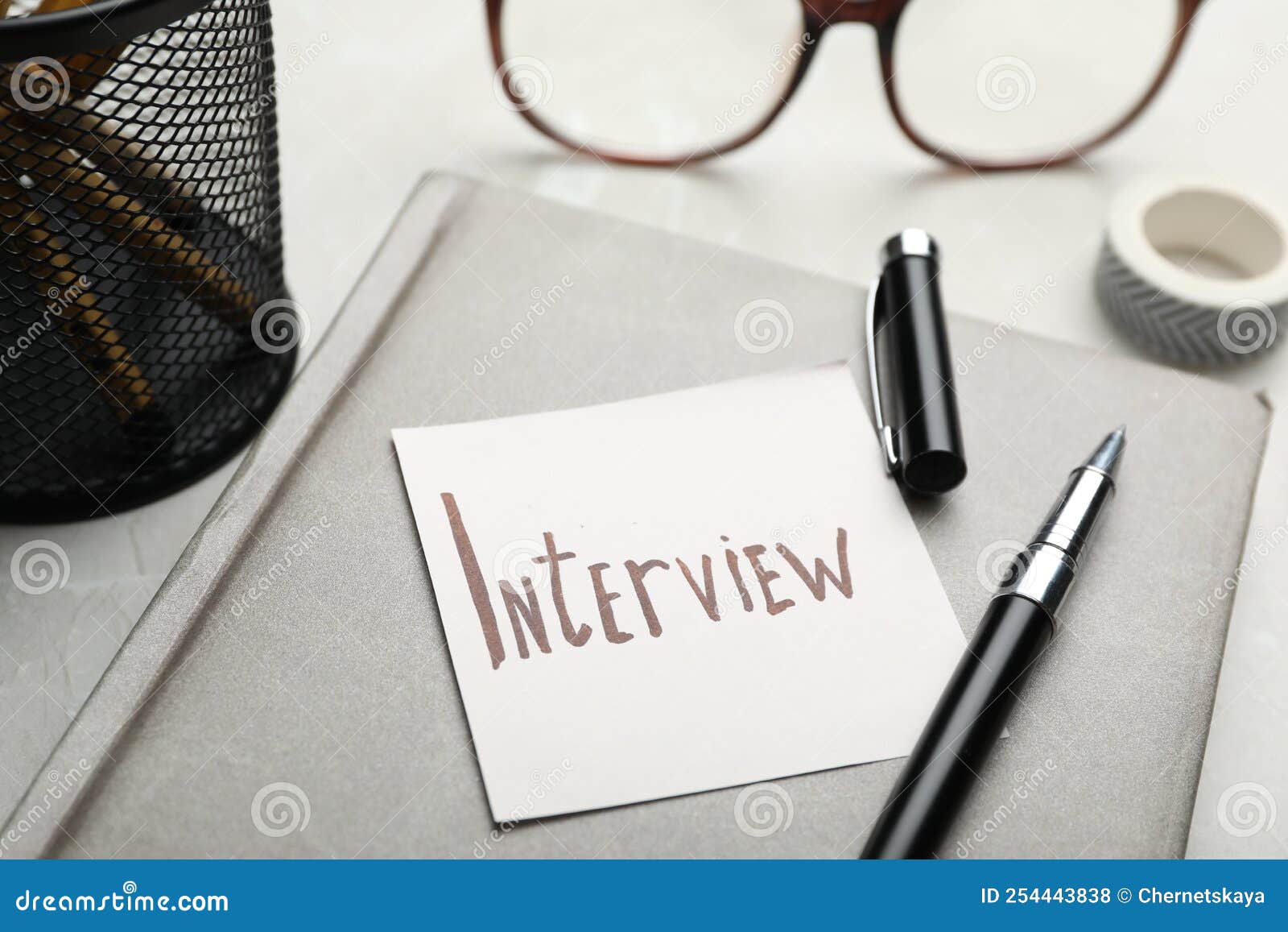 Reminder Note about Job Interview and Stationery on Table, Closeup