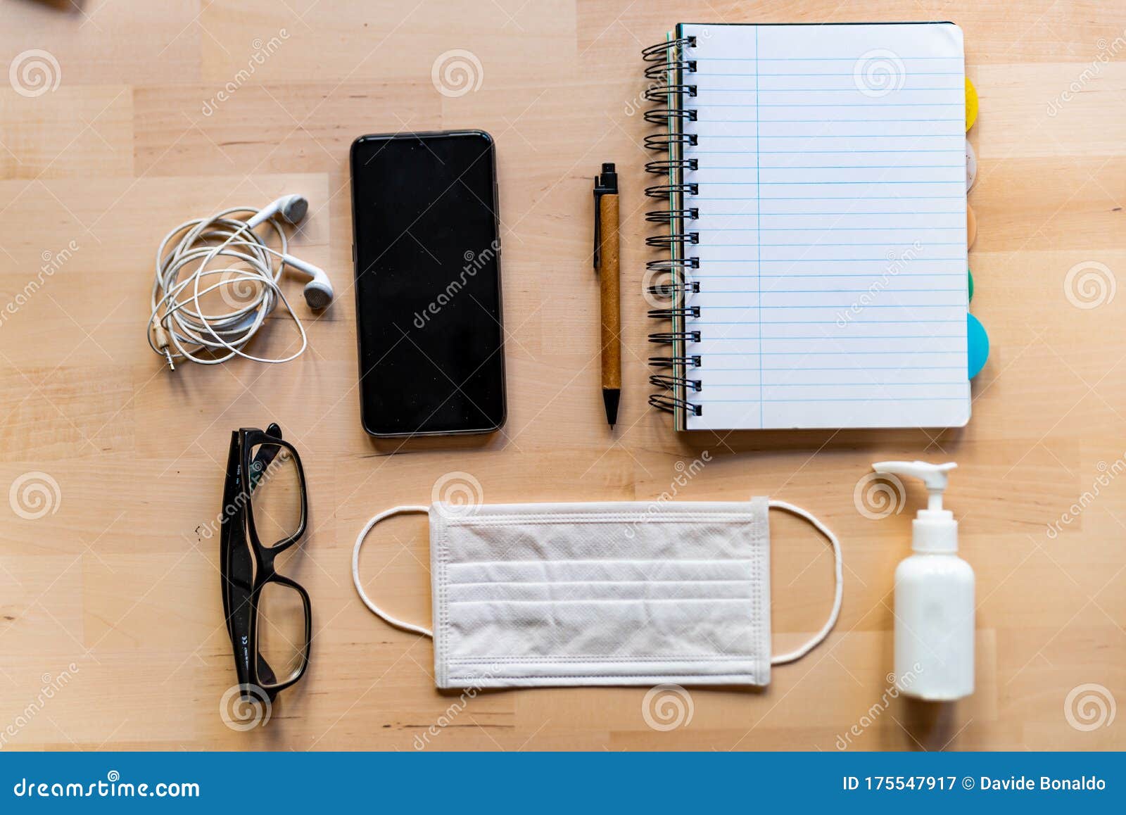 remote work kit on wooden office desk with hand sanitizer and face mask, a solution against the spread of corona virus for