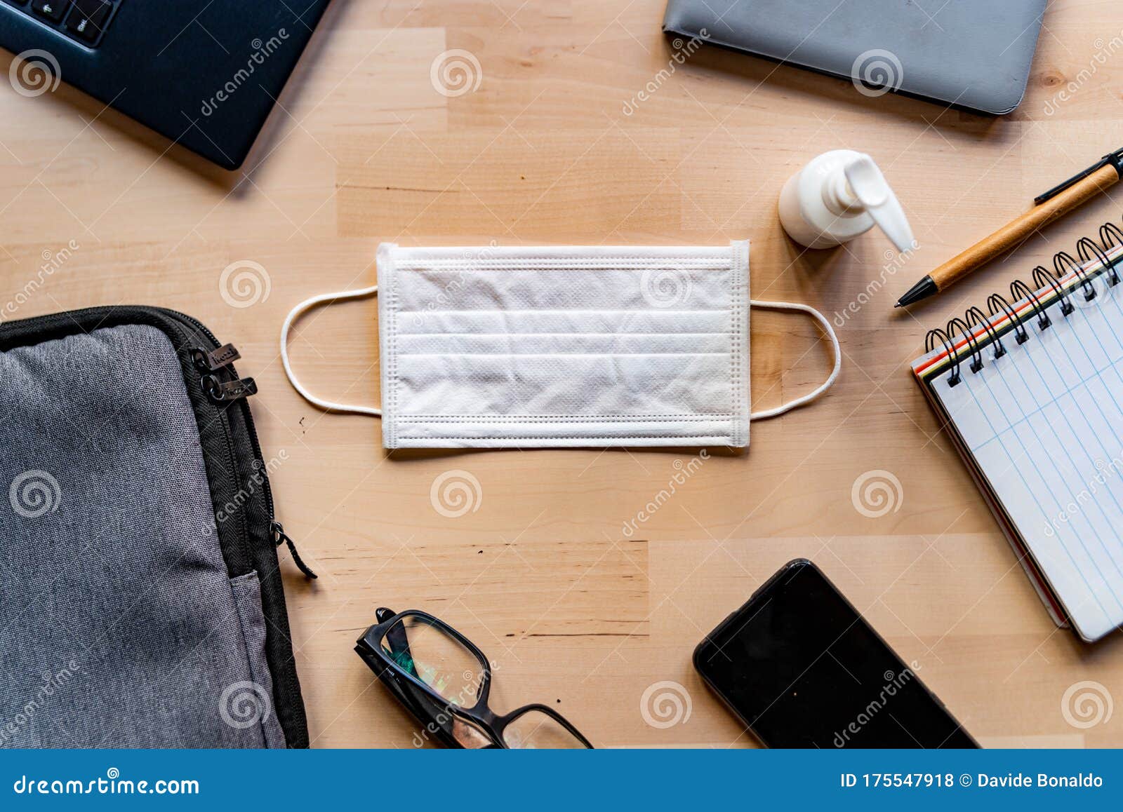 remote work kit on wooden office desk with hand sanitizer and face mask, a solution against the spread of corona virus for