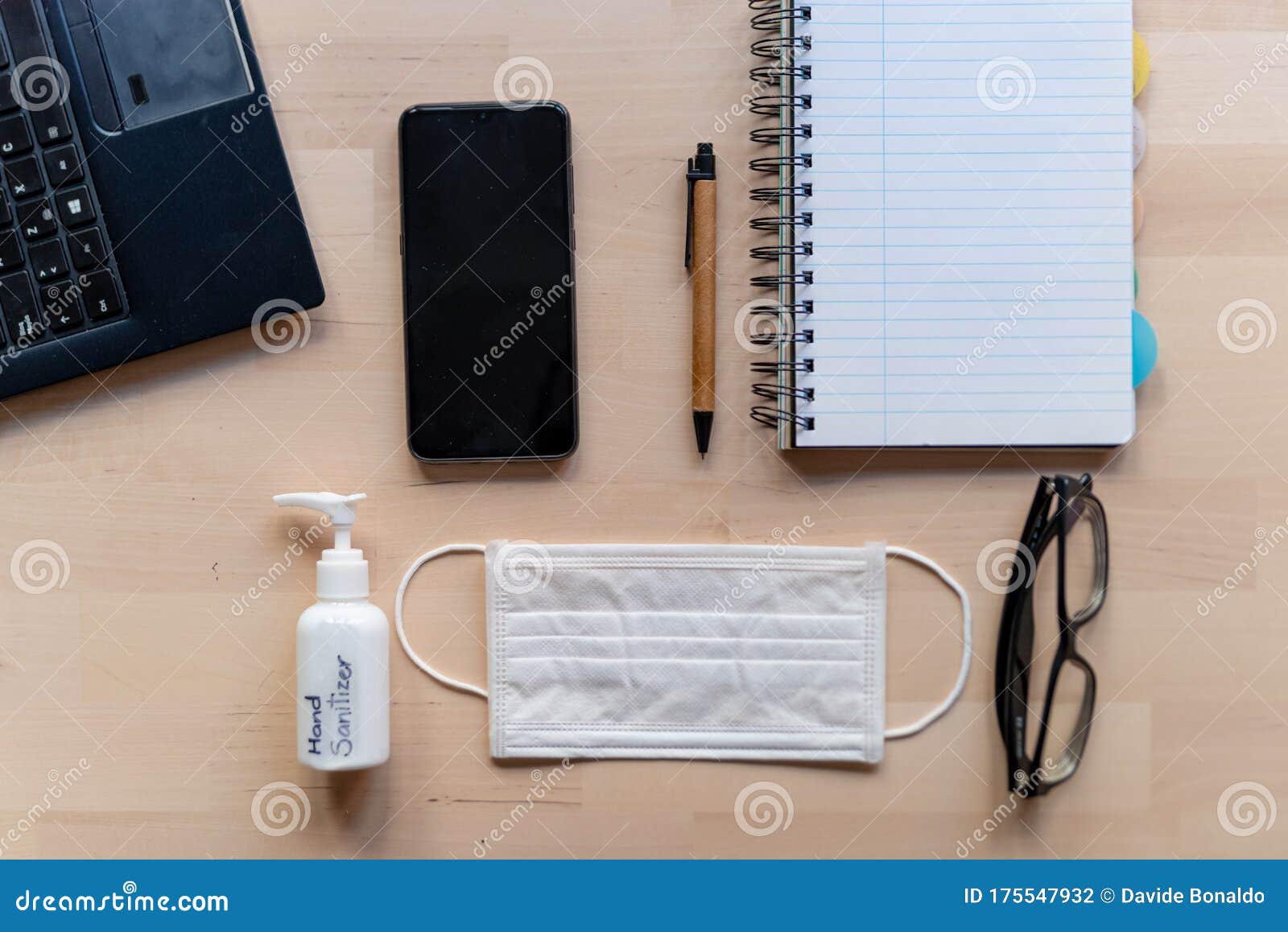 remote work kit on wooden office desk with hand sanitizer and face mask, a solution against the spread of corona virus for