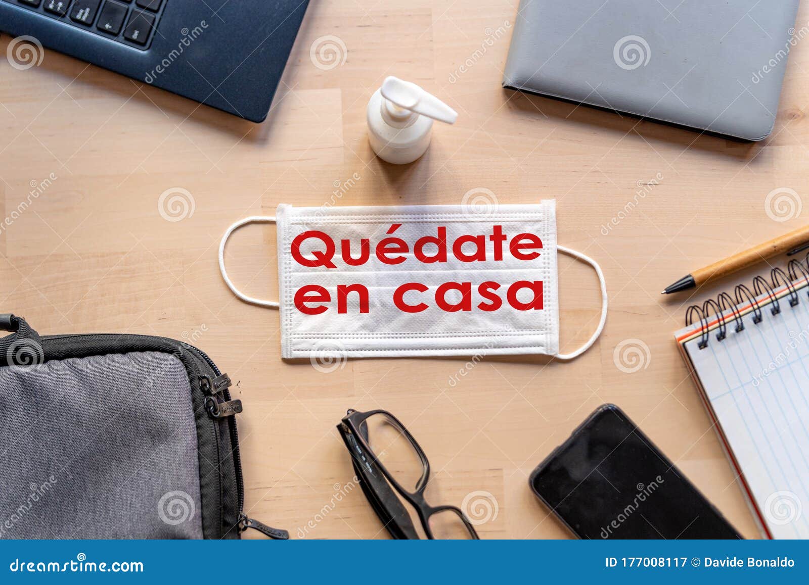 remote work kit on wooden office desk with hand sanitizer and face mask, a solution against the spread of corona virus for