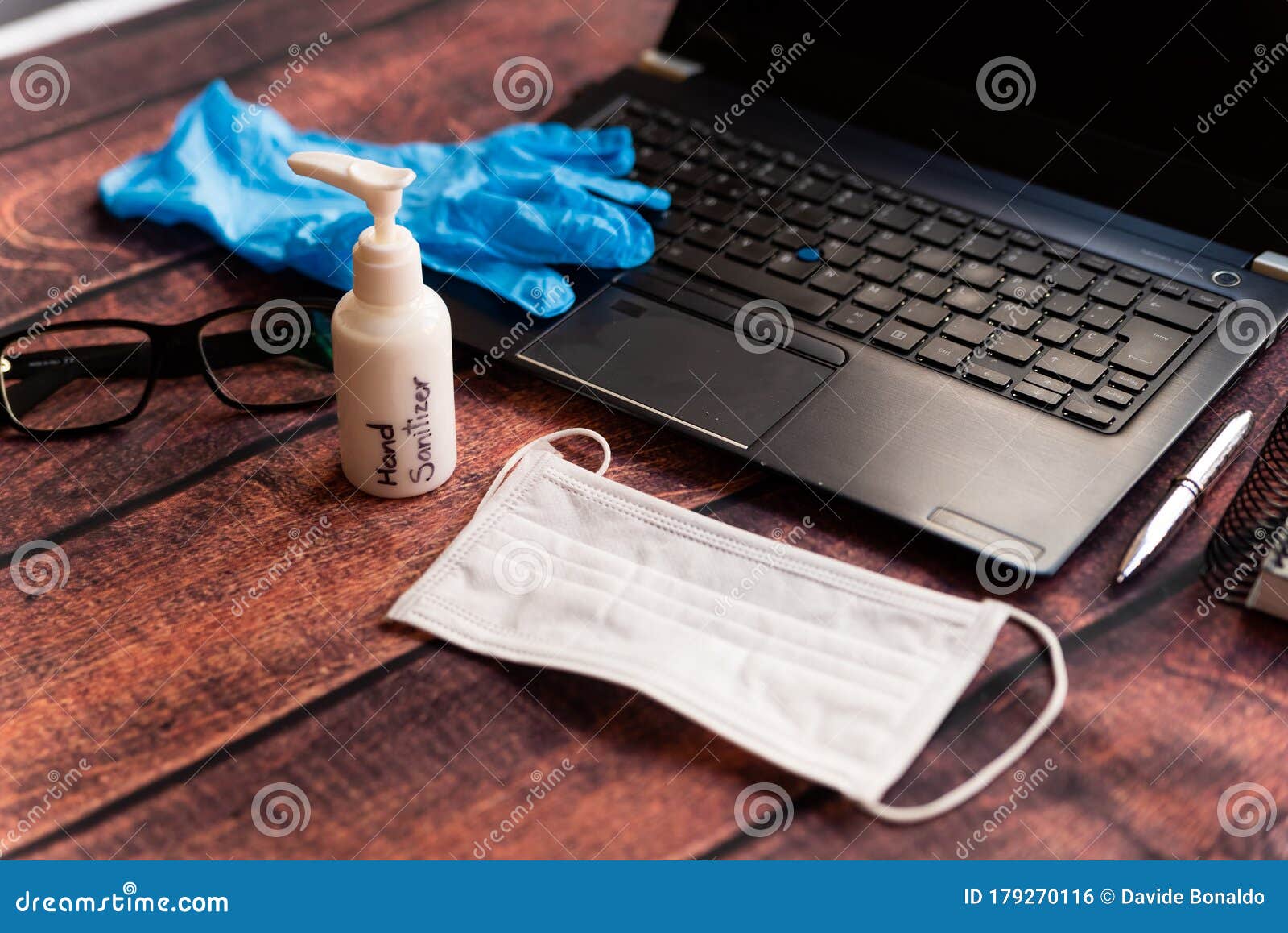 remote work kit on wooden office desk with hand sanitizer and face mask, a solution against the spread of corona virus for