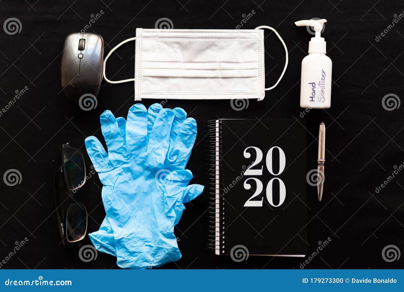 remote work kit on wooden office desk with hand sanitizer and face mask, a solution against the spread of corona virus for