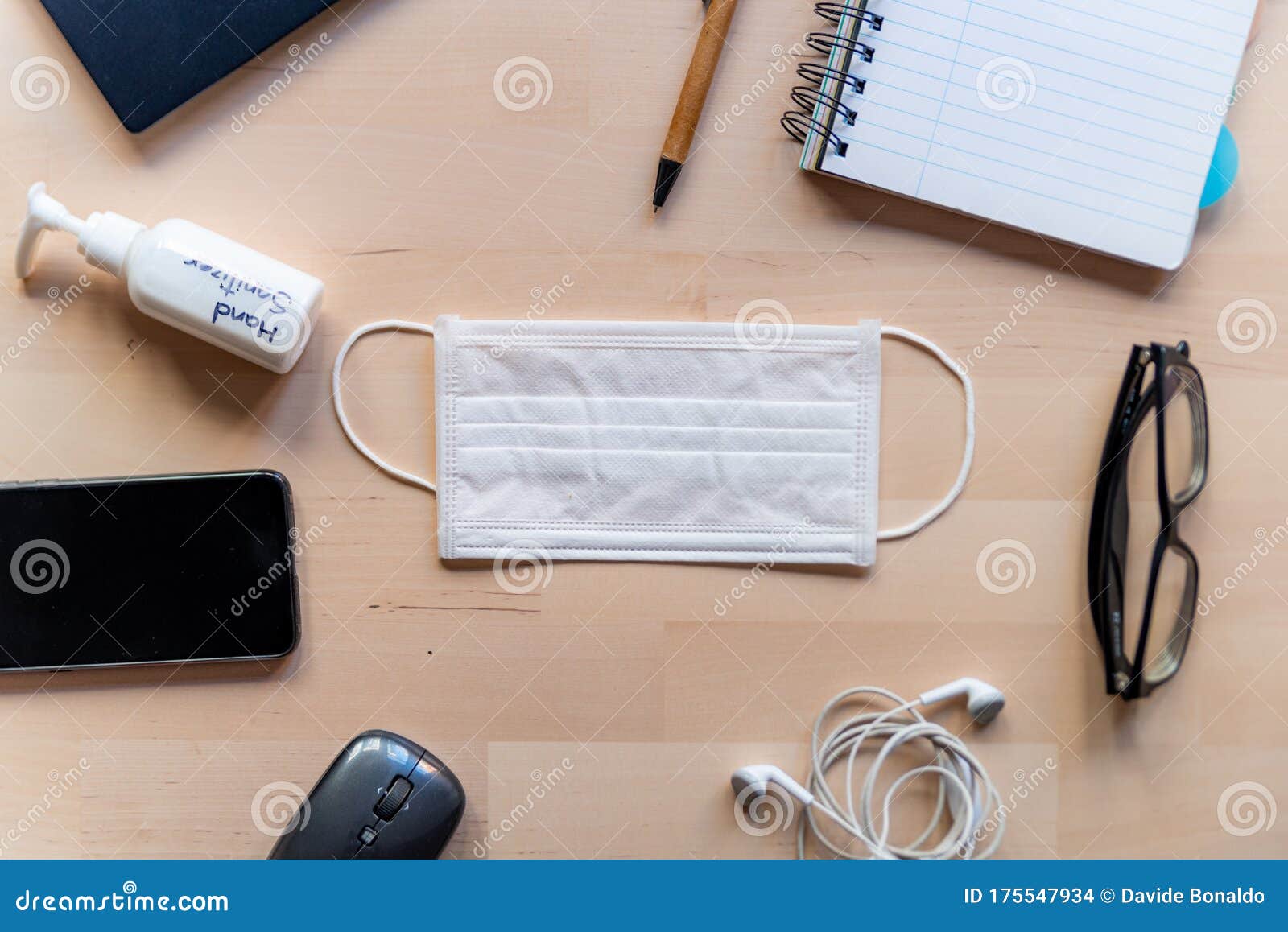 remote work kit on wooden office desk with hand sanitizer and face mask, a solution against the spread of corona virus for