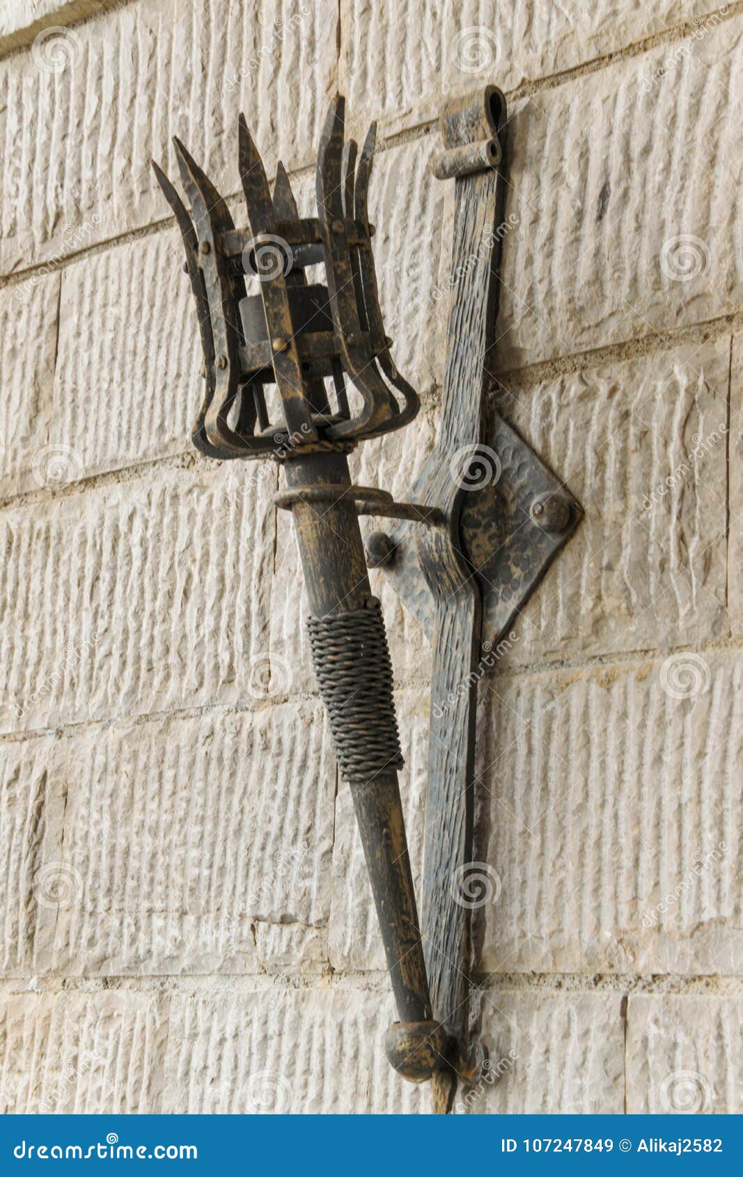 Removable Iron Torch on a Medieval Castle Stone Wall Stock Image